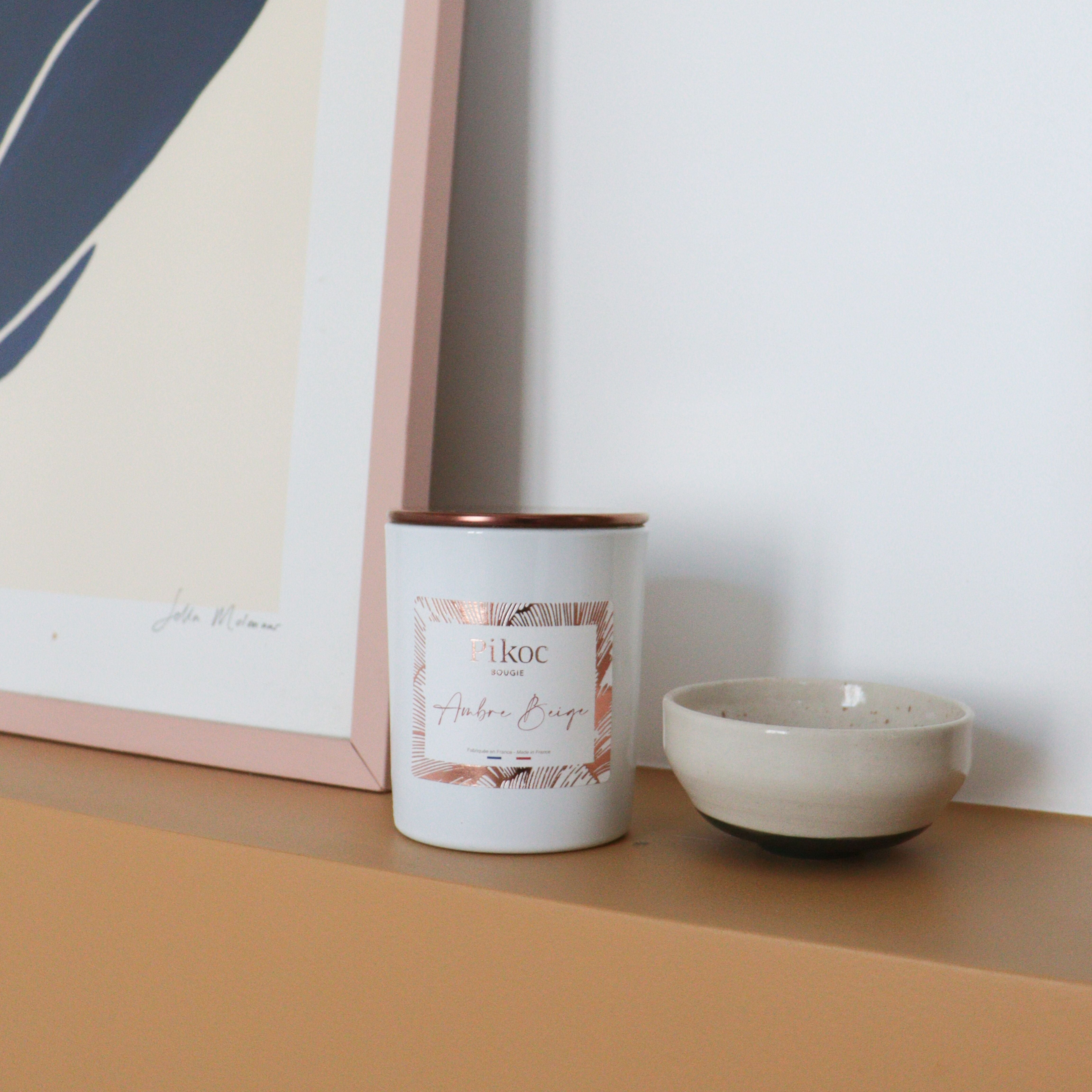 Bougie parfumée Pikoc Ambre Beige, 150g, posé sur un meuble avec son couvercle