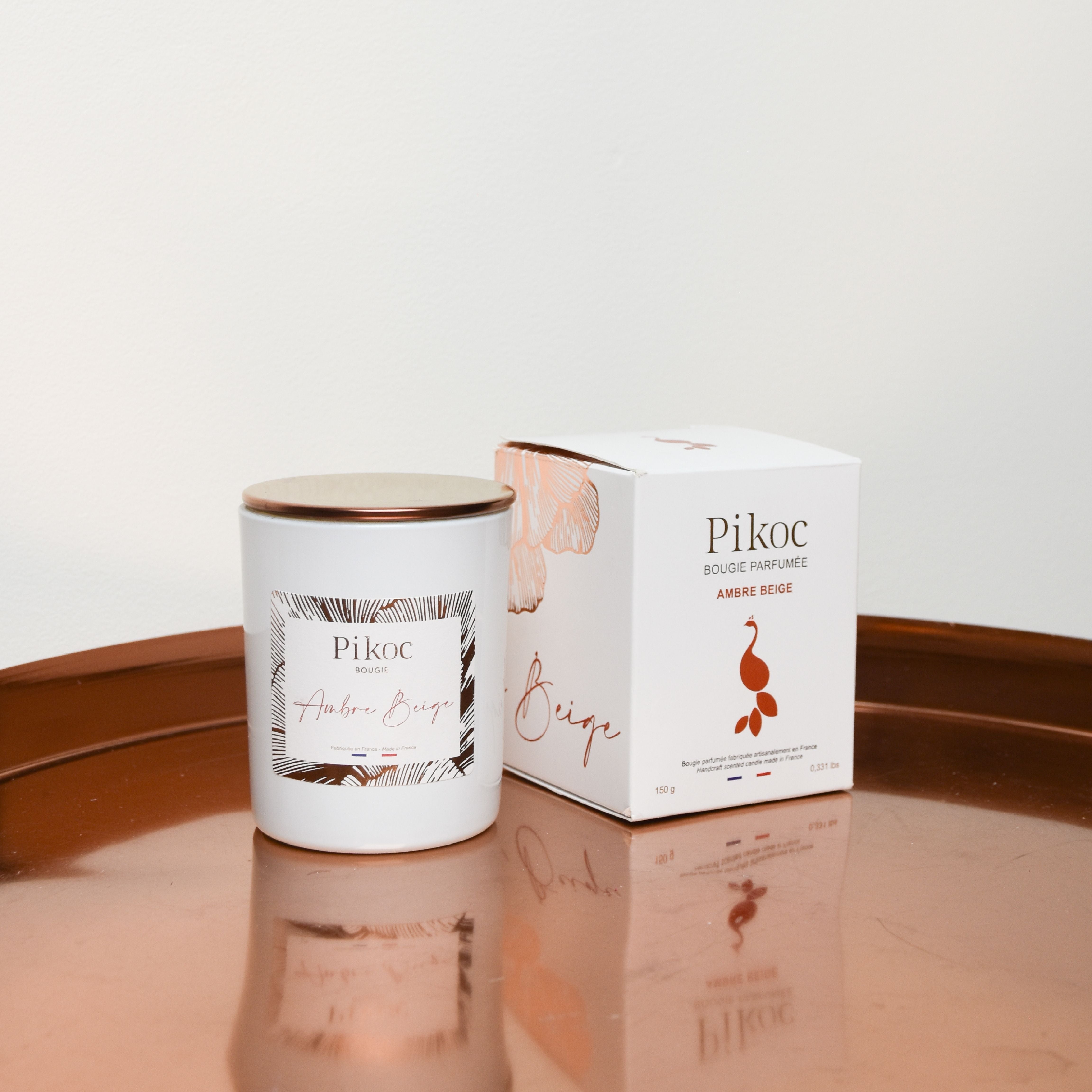 Bougie parfumée Pikoc Ambre Beige, 150g, posé sur un plateau avec sa boite et son couvercle