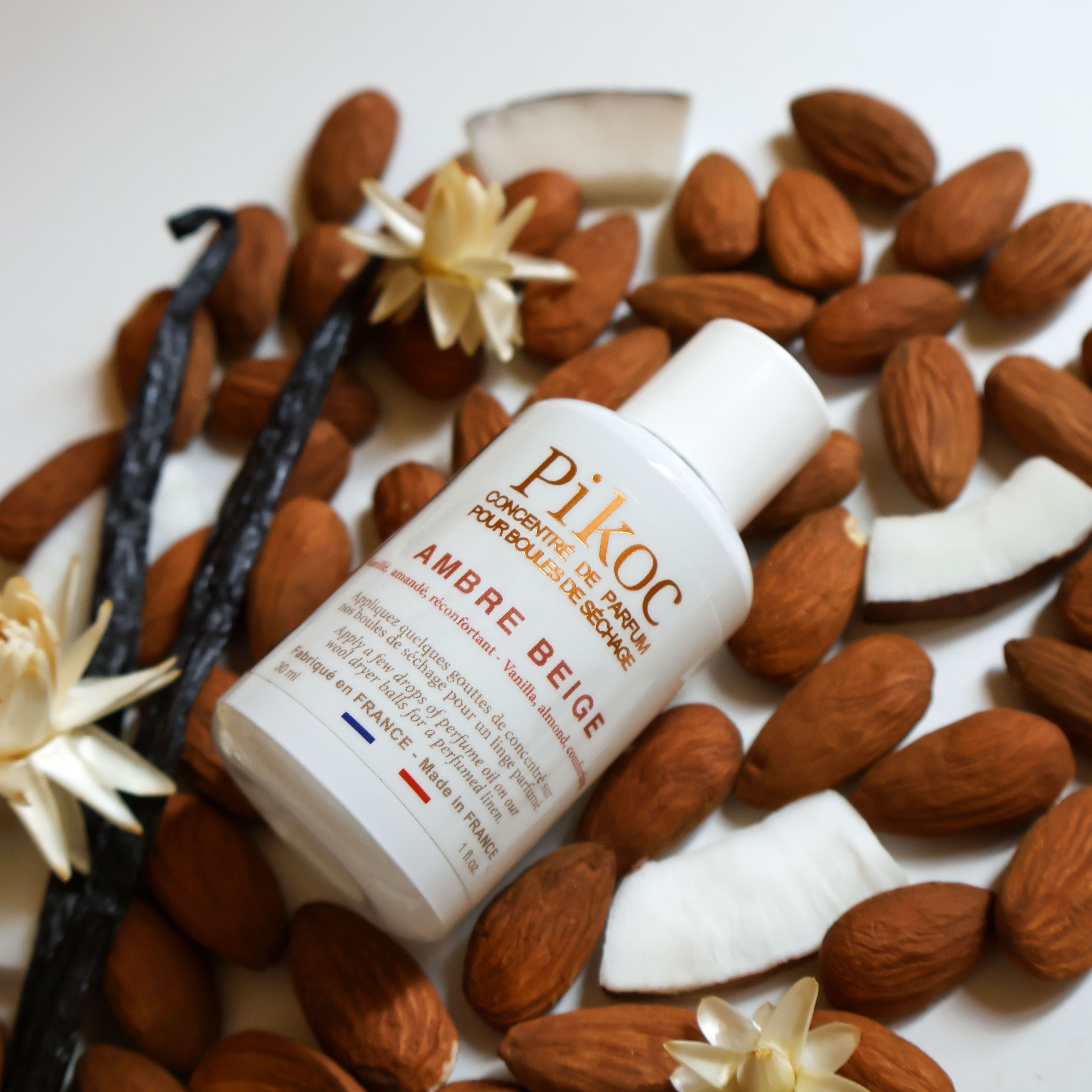 Concentré de parfum Pikoc Ambre Beige, 30mL, posé dans un vrac des ingrédients qui compose la fragrance