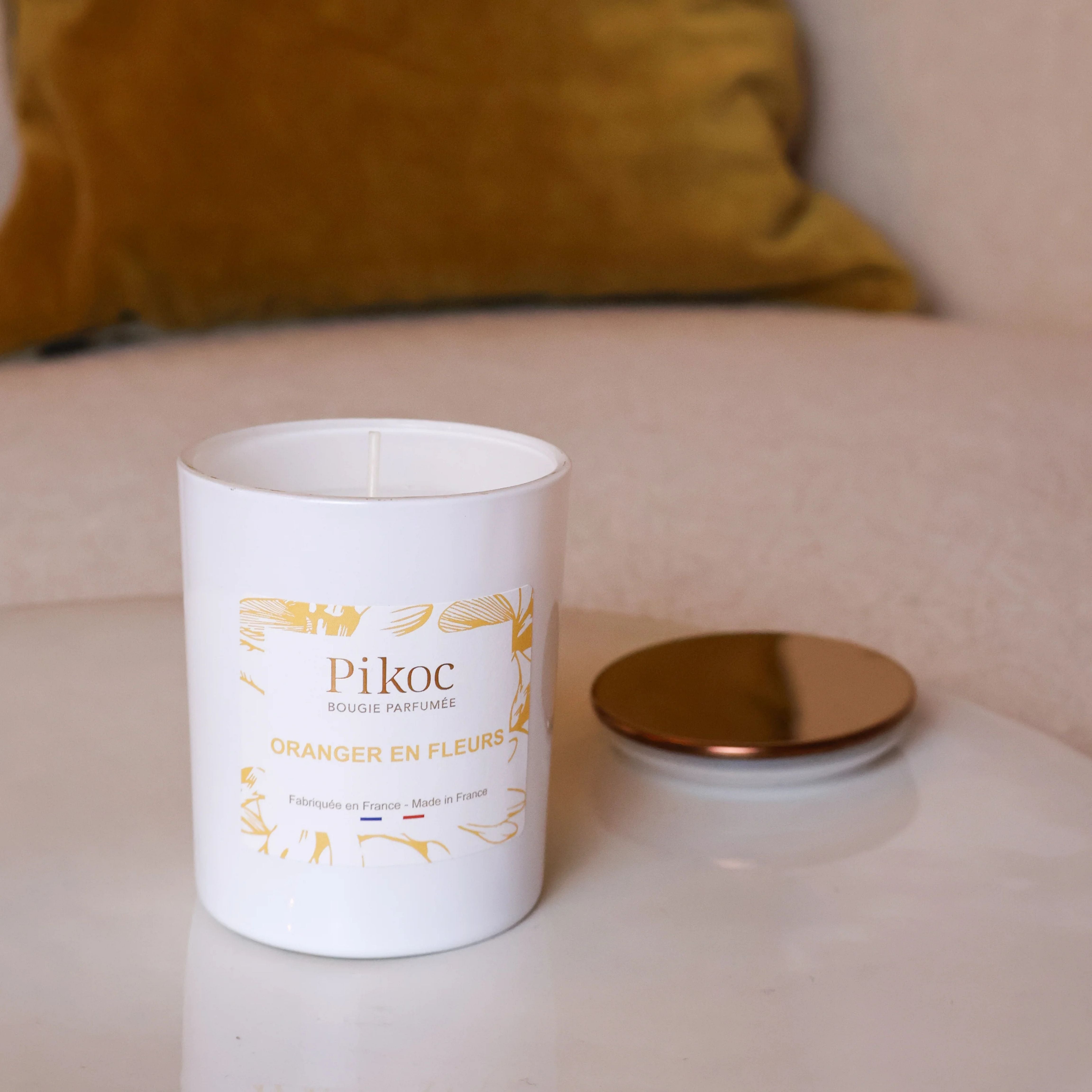 Bougie parfumée Pikoc Oranger en Fleurs, 150g, posé sur une table avec son couvercle