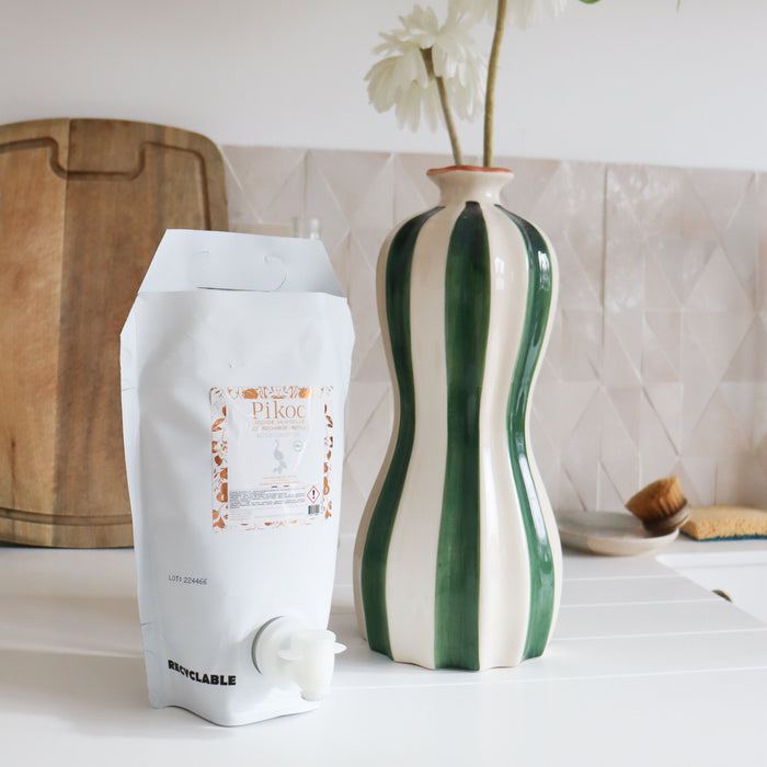 Éco-recharge Liquide vaisselle Pikoc Bois Eucalyptus, 1,5L, posé à côté d’un évier