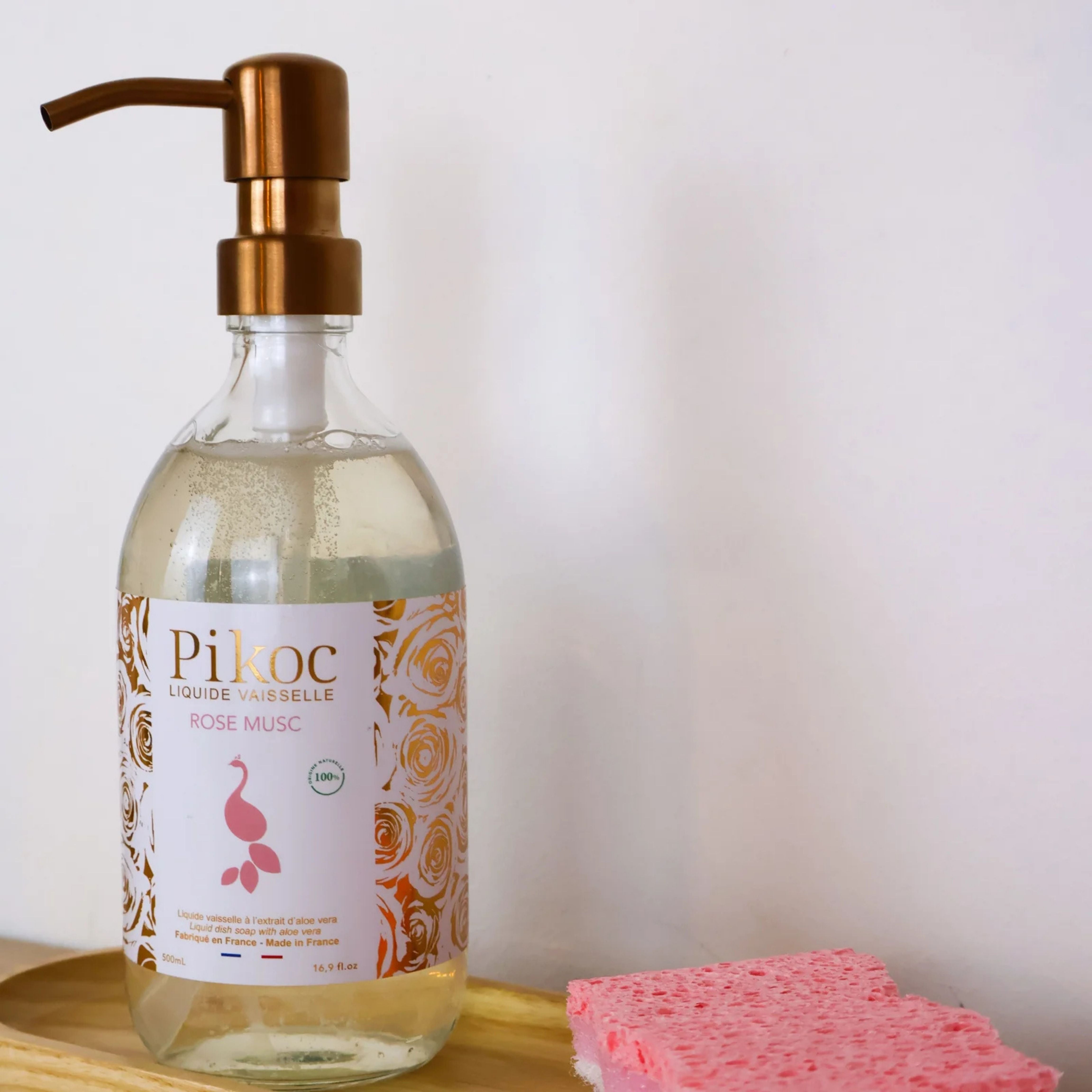 Liquide vaisselle Pikoc Rose Musc, 490mL, posé sur un socle avec une éponge de cuisine