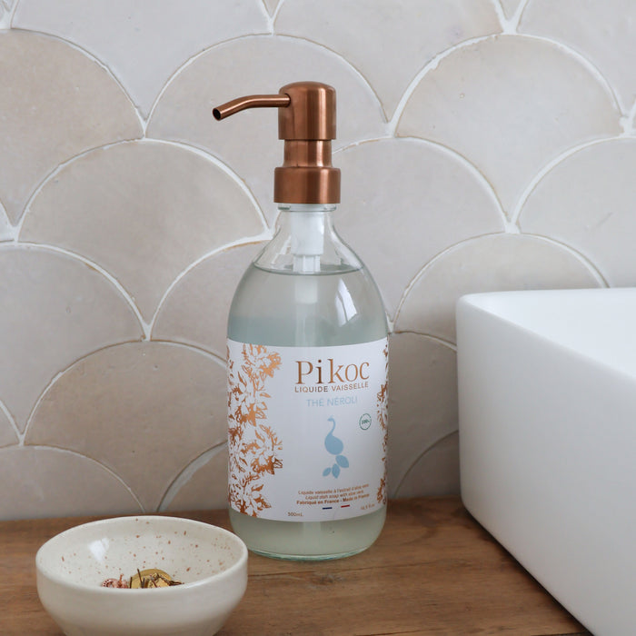 Liquide vaisselle Pikoc Thé Néroli, 490mL, posé à côté d’un évier
